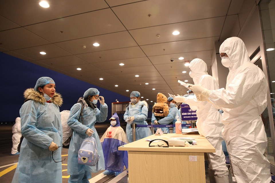 El personal del aeropuerto Van Don realizó los trámites de migración para los viajeros que regresaron de Wuhan (China). (Foto: VNA)