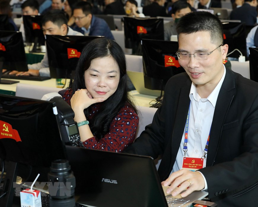 Reporteros cubren el XIII Congreso Nacional desde el Centro de Prensa. (Foto: VNA)