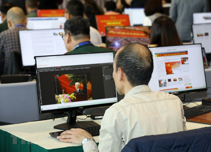 Reporteros cubren el XIII Congreso Nacional desde el Centro de Prensa. (Foto: VNA)