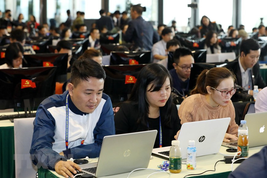 Reporteros cubren el XIII Congreso Nacional desde el Centro de Prensa. (Foto: VNA)