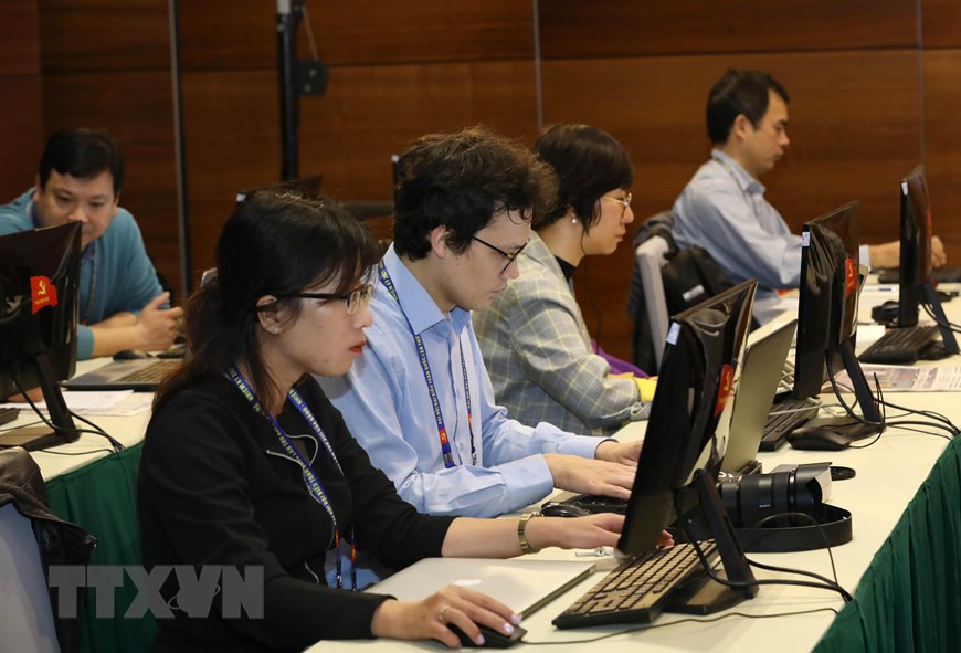 Reporteros cubren el XIII Congreso Nacional desde el Centro de Prensa. (Foto: VNA)