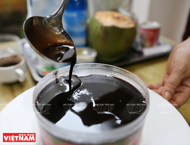 Se añade una capa final a la base del pastel (Foto: VNA)