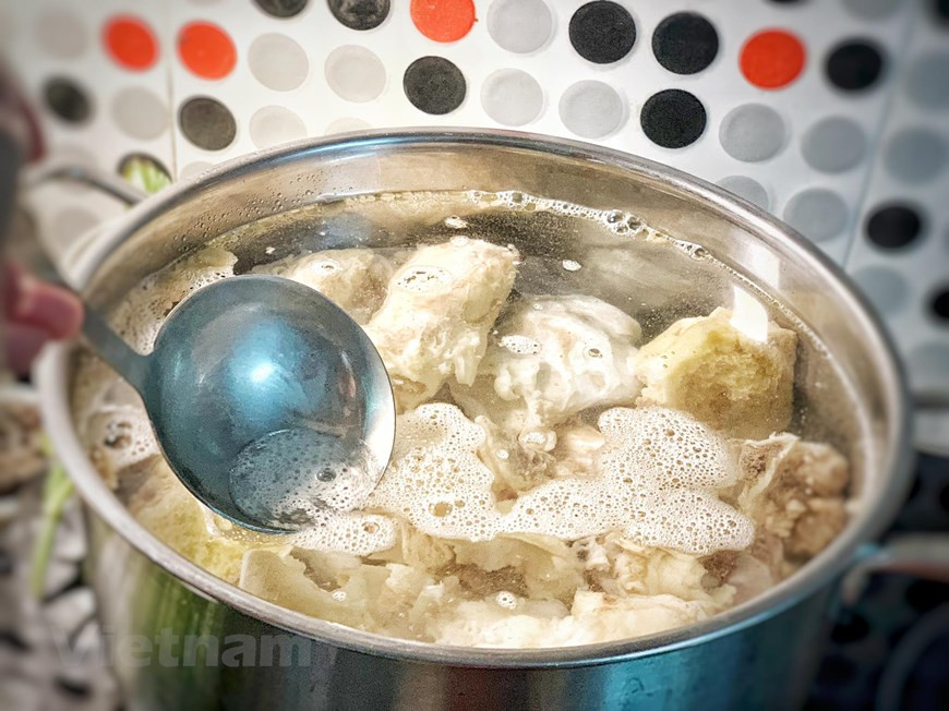 En una olla grande poner los huesos y la carne limpios, la cebolla y el jengibre. Añadir 2.5 litros de agua y cocinar a fuego lento sin que hierva durante 1 hora. Quitar las grasas e impurezas cuando aparezcan. Pasado este tiempo, añadir las chalotas, la bolsita con las especias, la sal, la salsa de pescado y el azúcar. Remover y dejar cocinar otras 2 horas más. Pasadas las 2 horas, retirar la carne y la dejarla enfriar completamente en un bol con agua, para evitar que se oscurezca. Cuando la carne esté completamente enfriada, cortarla con cuidado ya que se rompe fácilmente. (Fuente: VietnamPlus)