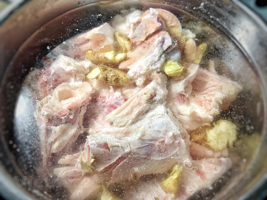 Hervir los huesos y el morcillo, cuando rompa a hervir esperar 5 minutos y tirar el agua. Limpiar bien los huesos y la carne. En una olla grande poner los huesos y la carne limpios, la cebolla y el jengibre. Añadir 2.5 litros de agua y cocinar a fuego lento sin que hierva durante 1 hora. Quitar las grasas e impurezas cuando aparezcan. Pasado este tiempo, añadir las chalotas, la bolsita con las especias, la sal, la salsa de pescado y el azúcar. Remover y dejar cocinar otras 2 horas más. Pasadas las 2 horas, retirar la carne y la dejarla enfriar completamente en un bol con agua, para evitar que se oscurezca. Cuando la carne esté completamente enfriada, cortarla con cuidado ya que se rompe fácilmente. (Fuente: VietnamPlus)