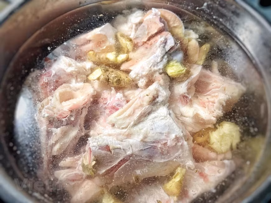 Hervir los huesos y el morcillo, cuando rompa a hervir esperar 5 minutos y tirar el agua. Limpiar bien los huesos y la carne. En una olla grande poner los huesos y la carne limpios, la cebolla y el jengibre. Añadir 2.5 litros de agua y cocinar a fuego lento sin que hierva durante 1 hora. Quitar las grasas e impurezas cuando aparezcan. Pasado este tiempo, añadir las chalotas, la bolsita con las especias, la sal, la salsa de pescado y el azúcar. Remover y dejar cocinar otras 2 horas más. Pasadas las 2 horas, retirar la carne y la dejarla enfriar completamente en un bol con agua, para evitar que se oscurezca. Cuando la carne esté completamente enfriada, cortarla con cuidado ya que se rompe fácilmente. (Fuente: VietnamPlus)