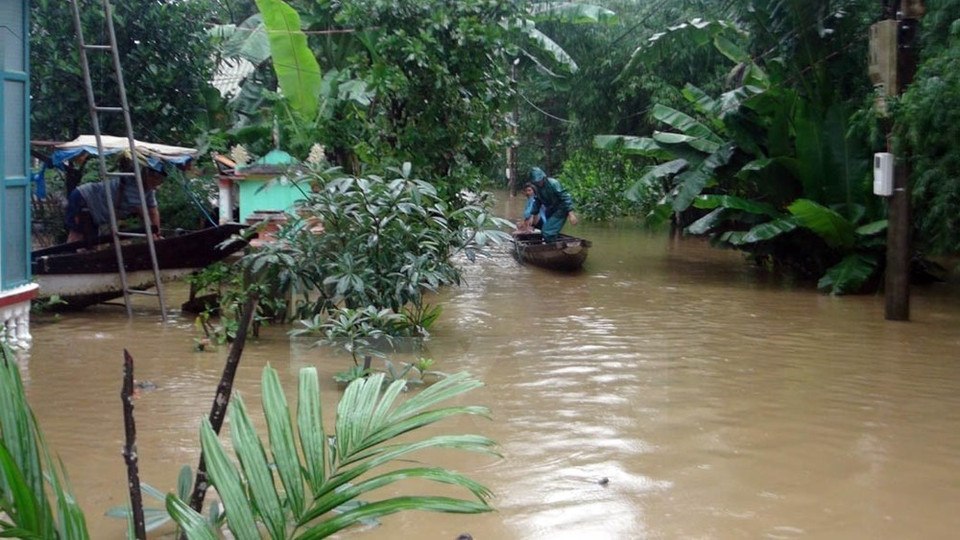 Los residentes locales usan un bote para moverse en una carretera inundada (Foto: VNA)