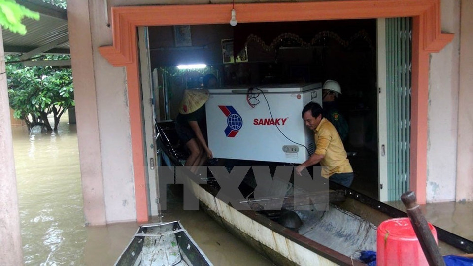 Las personas ayudan a una familia local a evacuar activos en un área inundada en la provincia de Quang Tri (Foto: VNA) 