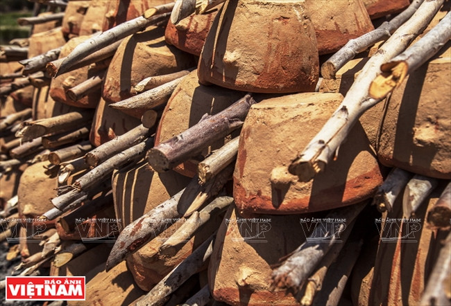  Se apilan las piezas cerámicas crudas con leñas en capas para honerarlas.
