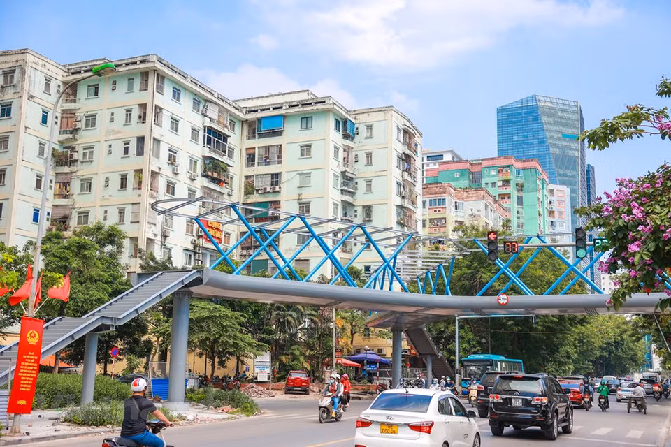 El puente peatonal de tres vías conecta la acera de la calle Hoang Minh Giam a lo largo del parque Thanh Xuan con dos esquinas separadas a cada lado de la calle Nguyen Thi Thap en el distrito de Thanh Xuan. Ubicada en la región septentrional, la capital vietnamita constituye la segunda mayor ciudad del país tras Ciudad Ho Chi Minh. Situada en la margen derecha del río Rojo, Hanoi cuenta con una superficie total de más de tres mil 300 kilómetros cuadrados y una población que supera los ocho millones de habitantes. En 2020, a pesar del impacto de la pandemia de COVID-19, Hanoi mantuvo su crecimiento económico, con el aumento del Producto Interno Bruto (PIB) regional de 3,98 por ciento, 1,5 veces más alto que el promedio nacional (Fuente: Vietnam+)