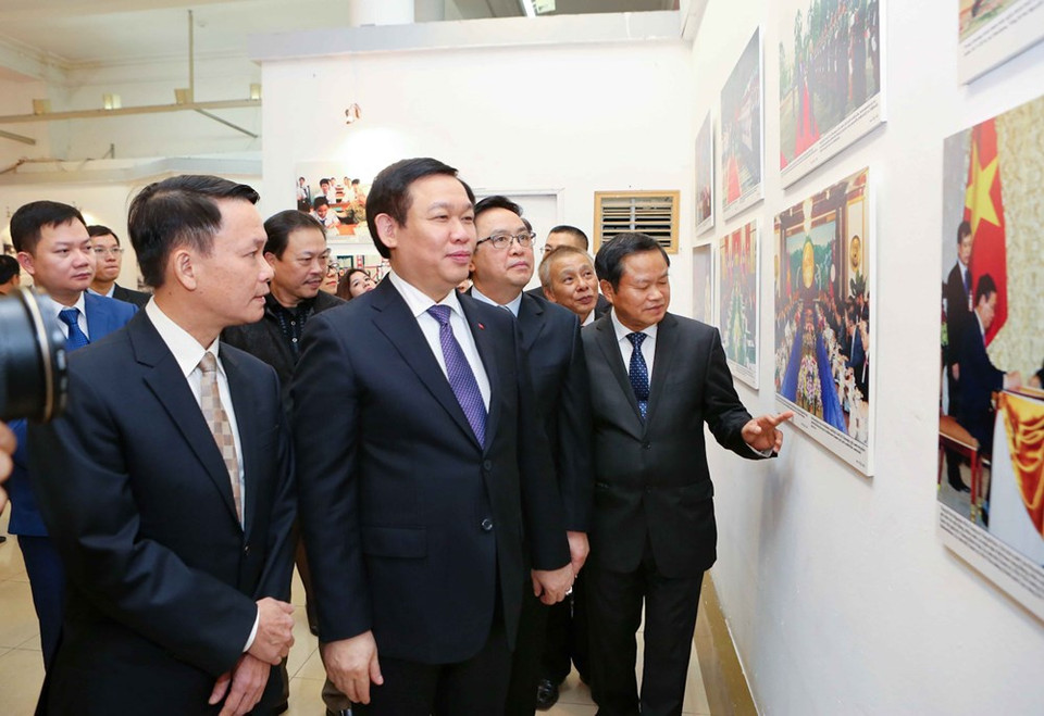 El viceprimer ministro de Vietnam Vuong Dinh Hue (segunda persona desde izquierda) contempla las instatáneas (Fuente: VNA)