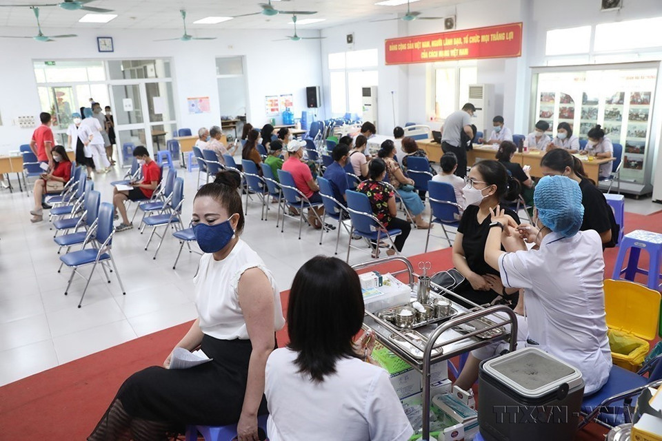 Con el fin de cubrir rápidamente la vacuna contra la COVID-19 y limitar la propagación de la epidemia, los centros de salud del distrito de Hanoi han acelerado la vacunación contra la COVID-19, especialmente las terceras y cuartas dosis para personas (agosto de 2022). (Foto: VNA)