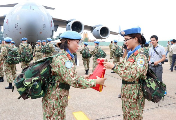 Las mujeres soldadas doblan sus banderas nacionales y se preparan para ir a la misión. (Foto: VNA)