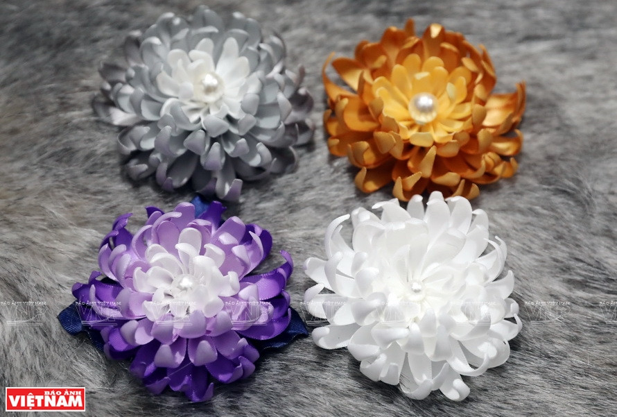 Los broches de flores son hechos con diferentes materiales, estilos y colores (Foto: VNA)