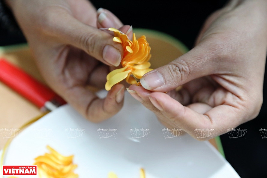 La artesana cose los pétalos de las flores a mano (Foto: VNA)