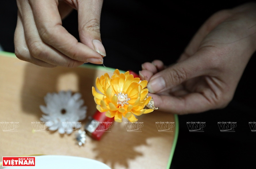 La artesana decora los broches con las cuentas (Foto: VNA)