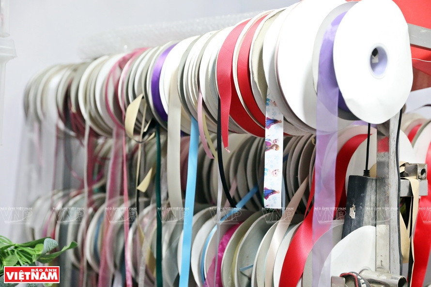 Uno de los materiales para el broche de flores es la cinta de seda (Foto: VNA)