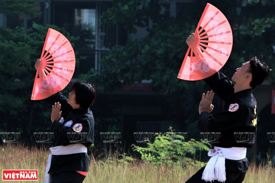 Discípulos de la escuela de artes marciales Tan Khanh Ba Tra practican la lucha con abanicos (Foto: VNA)