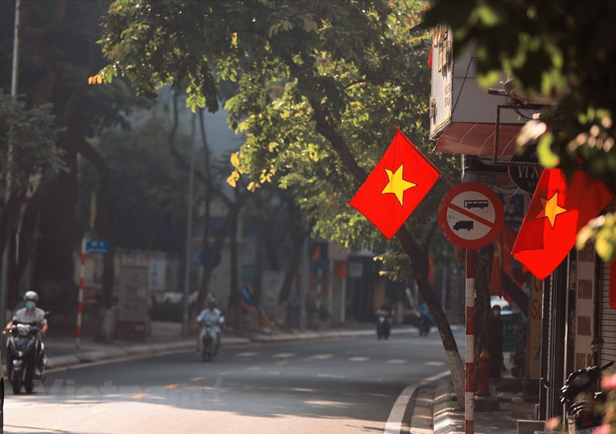 En tanto, muchos hogares comenzaron a colgar las banderas rojas con la estrella dorada para celebrar el Día Nacional de Vietnam, que se conmemora el 2 de septiembre cada año. En las calles bordeadas de árboles grandes, la imagen de los rayos de sol atravesando los follajes, junto con la caída de las hojas, brinda un entorno poético a la capital milenaria. No solo el paisaje, el aire fresco del otoño también hace que las personas se vuelvan más entrañables. No se sabe desde cuándo esta estación se ha convertido en una característica singular grabada en el corazón de los ciudadanos de la capital dondequiera que estén. (Foto: Vietnam+)