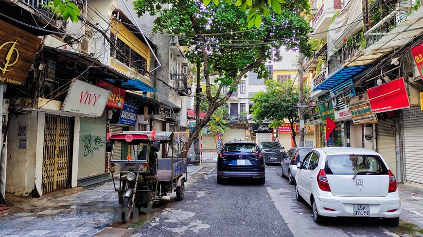 Vehículos estacionados frente a las tiendas cerradas en el centro de Hanoi. Las concurridas calles de la urbe se vuelven extrañamente tranquilas. Las barricadas se instalan en muchos lugares de la ciudad, en pos de garantizar las labores de prevención y control antiepidémico según la Directiva 17 del Comité Popular municipal. La urbe planea ampliar la campaña de inmunización contra la enfermedad en los últimos tres meses del año, cuando posiblemente se le asigne una mayor cantidad de vacunas. En ese sentido, se instó a las autoridades y agencias de salud locales a asegurar los preparativos para que ese proceso se lleve a cabo de manera segura, efectiva y oportuna. (Foto: Vietnam+)