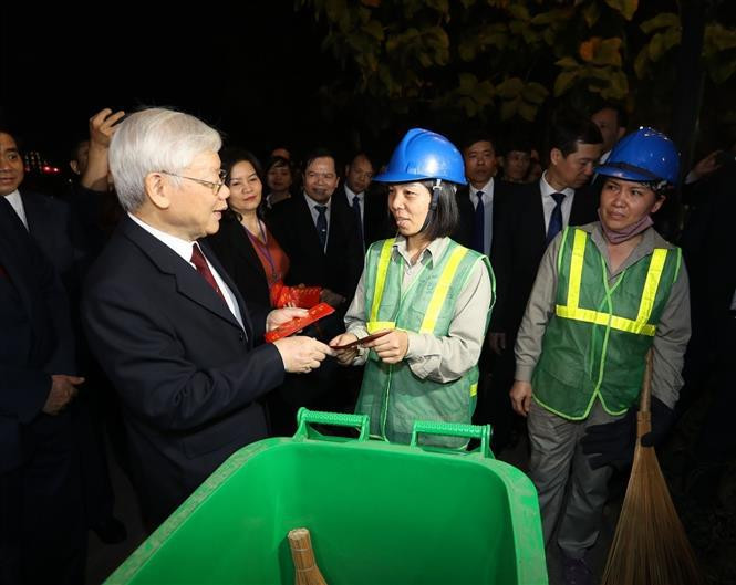 La noche del 4 de febrero de 2019, el entonces secretario general del Partido Comunista y presidente de Vietnam, Nguyen Phu Trong, visitó y regaló obsequios a los empleados ambientales que tenían que trabajar en la víspera de Año Nuevo Lunar (Foto: VNA)