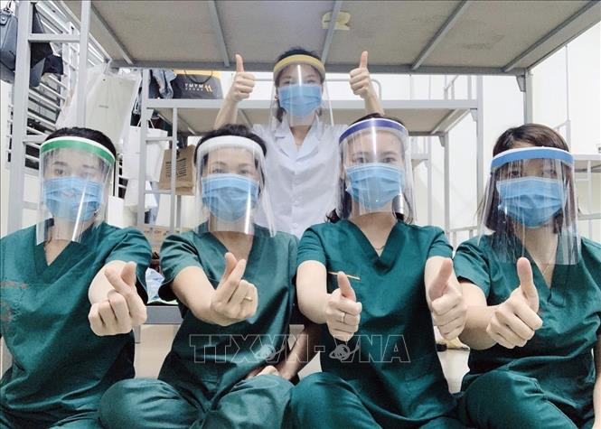 Las empleadas médicas del Hospital Central de Enfermedades Tropicales en el distrito de Dong Anh de Hanoi muestran su determinación de controlar con éxito la pandemia del COVID-19 (Fuente: VNA)