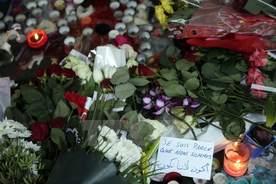 Candelas y flores colocadas en la entrada del café La Belle Equipe en París (Fuente: AFP/TTXVN)
