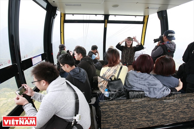Los turistas pueden tomar fotos y observar paisajes majestuosos de la cordillera de Hoang Lien desde la cabina, de capacidad máxima de 35 personas. Foto: Viet Cuong