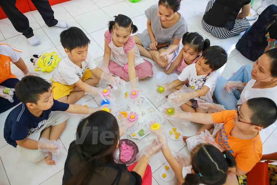 Los padres preparan los ingredientes, y los pequeños laminan la masa, cubren la guarnición con ella y la aprietan en el molde. (Fuente: VNA)