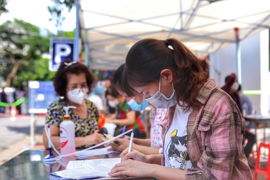 Pobladores del barrio Pham Dinh Ho, del distrito de Hai Ba Trung, realizan declaración médica antes de vacunarse (Fuente: VNA)