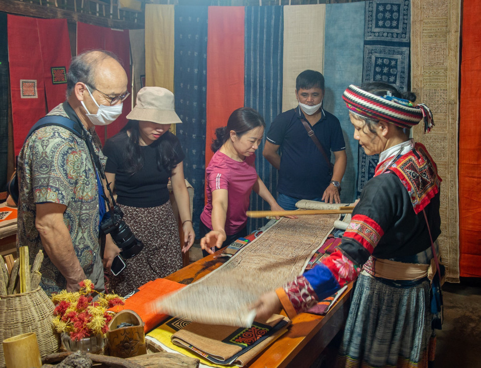 Los turistas visitan y compran productos tejidos con lino. (Foto: VNA)