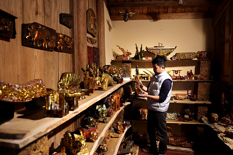 Pintor Nguyen Tan Phat junto con sus obras. (Foto: VNA)