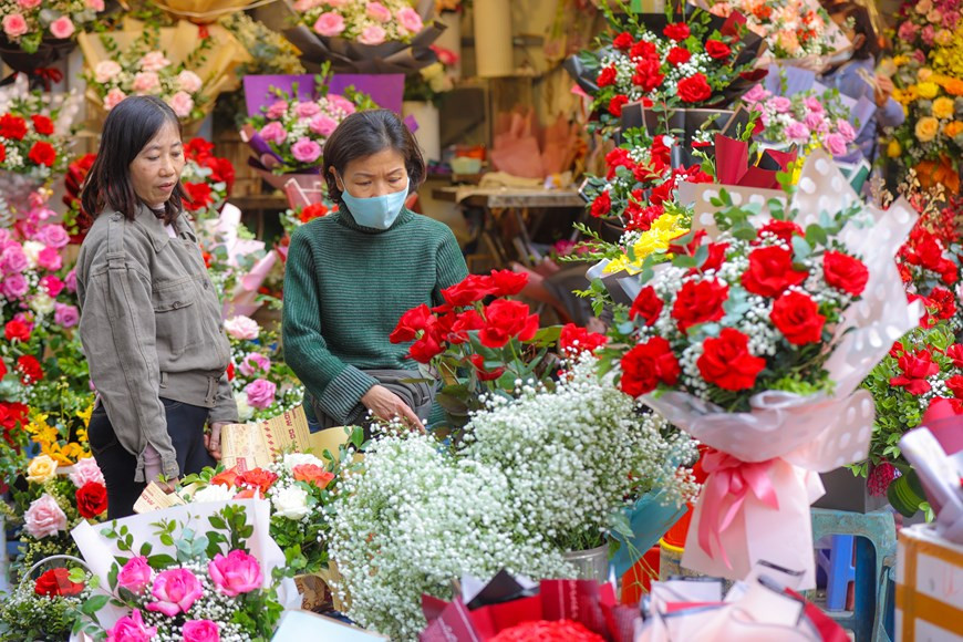 En la calle de Hang Ma, muchas tiendas han comenzado a vender regalos para que las parejas enamoradas puedan comprar y darse un regalo significativo en la noche del 14 de febrero. Las tiendas de flores en la calle de Tran Xuan Soan también están llenas de gente para comprar obsequios para sus enamorados. En un ambiente especial, muchas personas no pueden evitar sentirse encantados y sorprendidos cuando la calle de repente se vuelve hermosa y brillante con la aparición de carros de flores móviles. Aunque todavía no es de noche, las parejas se cogen de la mano cariñosamente, disfrutando del ambiente del Día de San Valentín. (Foto: PV/Vietnam+) 