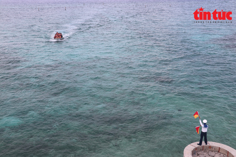 El soldado guía el barco a la isla de Da Tay B. (Foto: Periódico Tin Tuc)