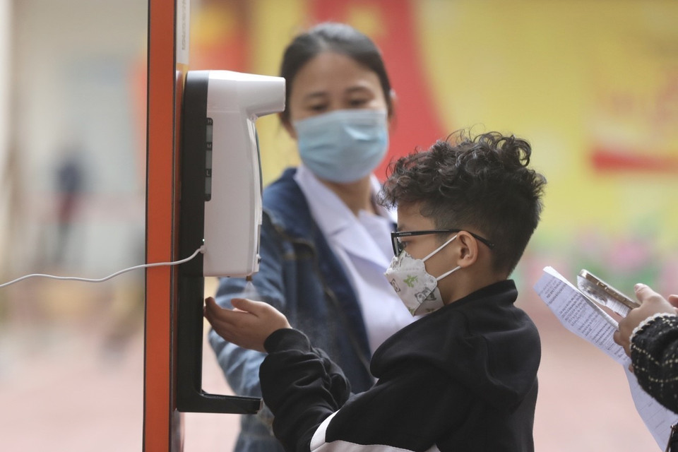 Al acudir a los puntos de vacunación, los alumnos y sus parientes reciben instrucciones médicas y la medición corporal. Foto: VNA