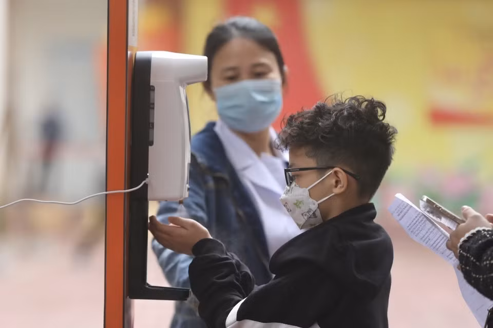 Al acudir a los puntos de vacunación, los alumnos y sus parientes reciben instrucciones médicas y la medición corporal. Foto: VNA