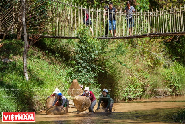 Viajeros pescan en un arroyo según el método de la comunidad minoritaria local.