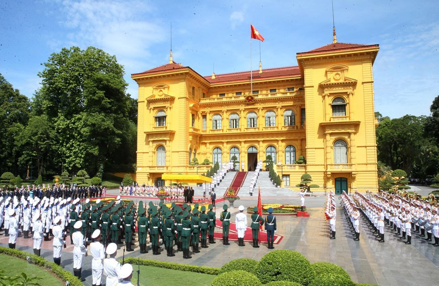 El presidente vietnamita Nguyen Xuan Phuc y el secretario general del PPRL y presidente de Laos, Thongloun Sisoulith, escuchan la música militar de ambos países. (Foto: VNA)