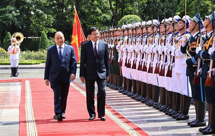 El jefe de Estado, Nguyen Xuan Phuc, y el secretario general del PPRL y presidente de Laos, Thongloun Sisoulith, pasan revista a la Guardia de Honor del Ejército Popular de Vietnam. (Foto: VNA)