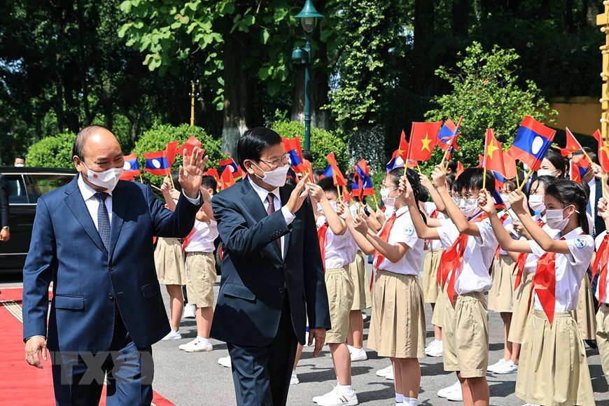 El presidente de Vietnam, Nguyen Xuan Phuc, y el secretario general del PPRL y presidente de Laos, Thongloun Sisoulith, con niños en Hanoi durante la ceremonia de bienvenida. (Foto: VNA) 