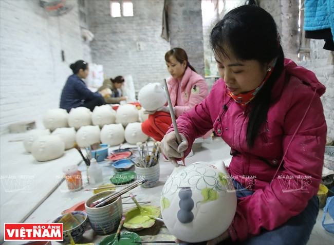 Artesanos pintan con esmaltes sus productos después del horneado. (Fuente: VNA)