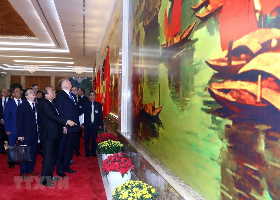 El primer ministro Nguyen Xuan Phuc presenta al presidente norteamericano, Donald Trump, cuadros de Vietnam. (Foto: VNA)