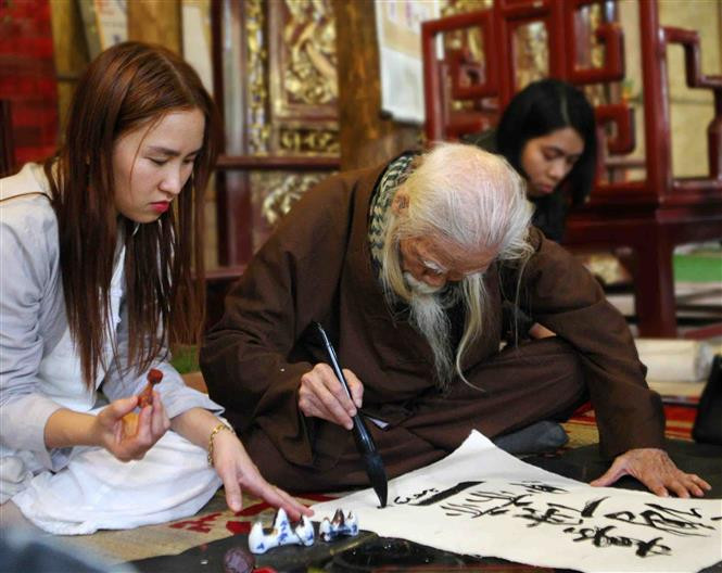 Presentación de arte caligráfico durante la ceremonia de apertura. (Fuente: VNA) uguró en el Templo de la Literatura, en Hanoi, en ocasión de las venideras fiestas del Tet, Año Nuevo Lunar del Cerdo de la Tierra. La tradición de pedir y regalar letras caligráficas en el Tet es para tener suerte durante el año.