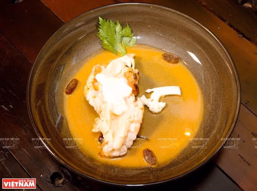 Cola de langosta con coliflor, mantequilla marrón, ron y pasas (Foto: VNA)