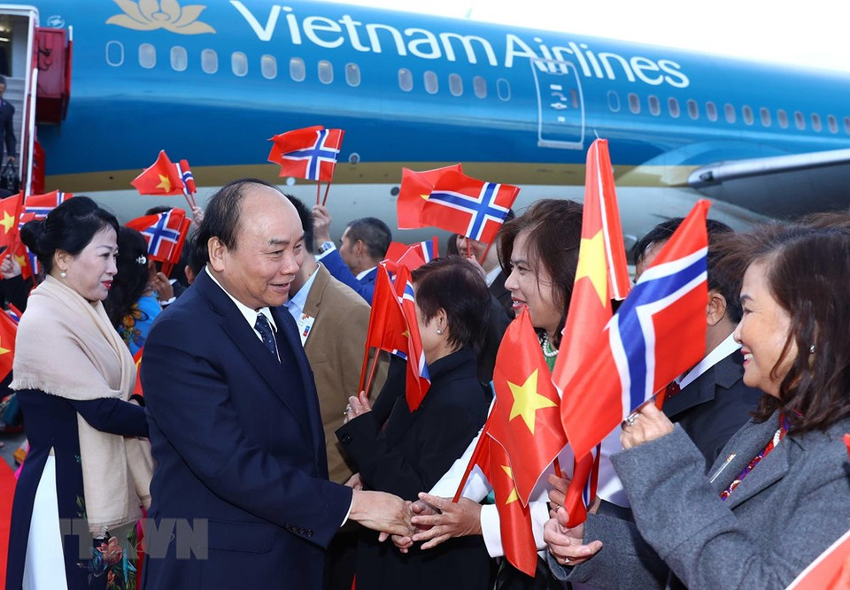 Funcionarios de la embajada y representantes de la comunidad vietnamita en Noruega dan la bienvenida al primer ministro Nguyen Xuan Phuc y su esposa en el aeropuerto Gardermoen. (Foto: VNA)