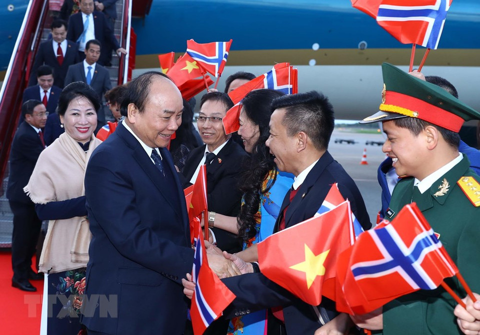Funcionarios de la embajada y representantes de la comunidad vietnamita en Noruega dan la bienvenida al primer ministro Nguyen Xuan Phuc y su esposa en el aeropuerto Gardermoen. (Foto: VNA)