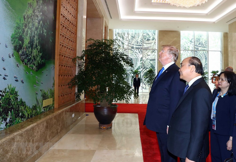 El primer ministro Nguyen Xuan Phuc presenta al presidente norteamericano, Donald Trump, cuadros de Vietnam. (Foto: VNA)