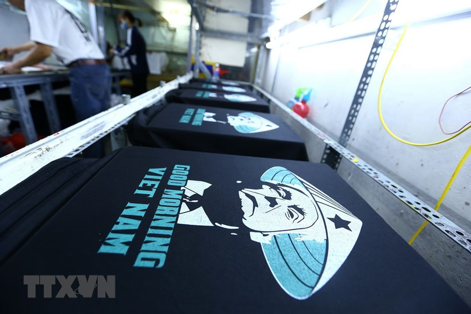 En estos días, en el taller de impresión de camisetas de Truong Thanh Duc en la calle Hang Bong se imprimen más de 300 unidades por día. (Foto: VNA)