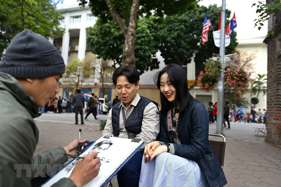 Turistas extranjeros hacen retratos en el lago Hoan Kiem. (Foto: VNA)