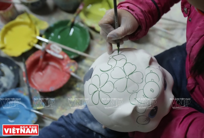 Artesanos pintan con esmaltes sus productos después del horneado. (Fuente: VNA)
