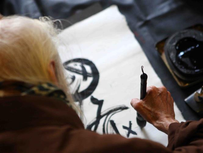 Viejo maestro escribe letras caligráficas. (Fuente: VNA)